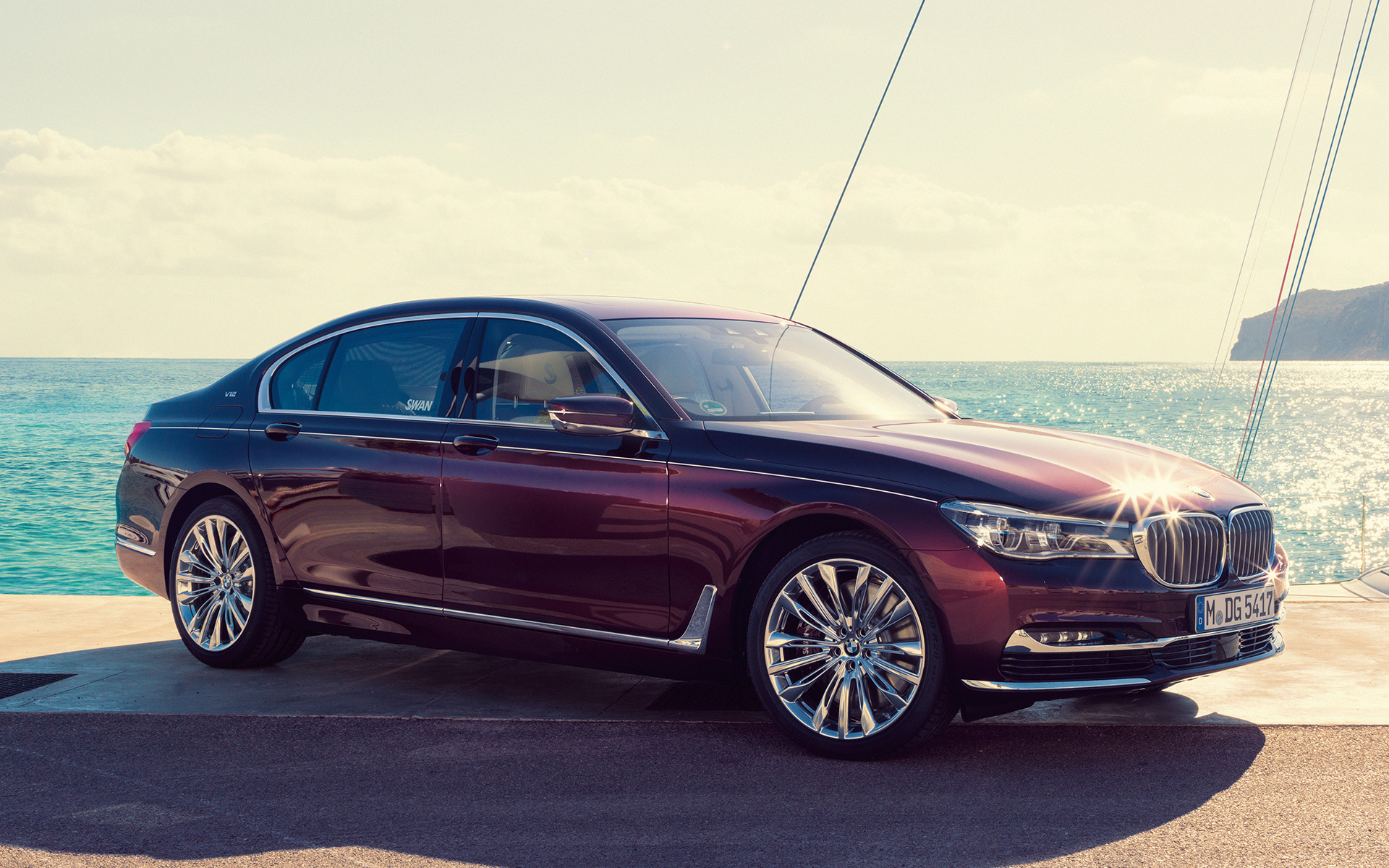 BMW Individual M760Li inspirée par Nautor’s Swan G12 2017 vue trois quarts latérale à l'arrêt sur la jetée devant un yacht à voile dans une baie